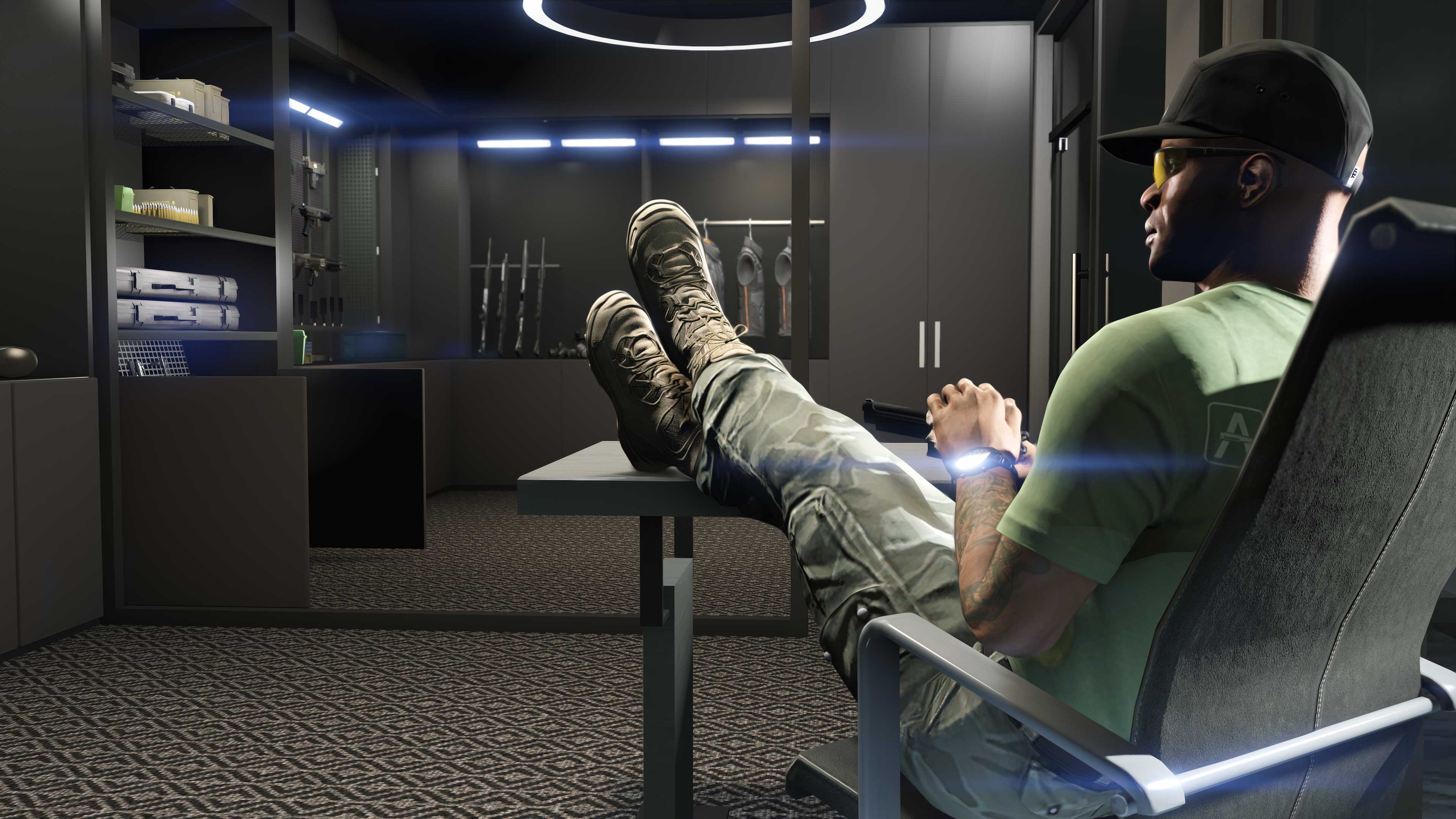 Um personagem do GTA Online reclinado em uma cadeira e descansando os pés sobre uma mesa, olhando para a sua coleção de armas, maletas e coletes balísticos.