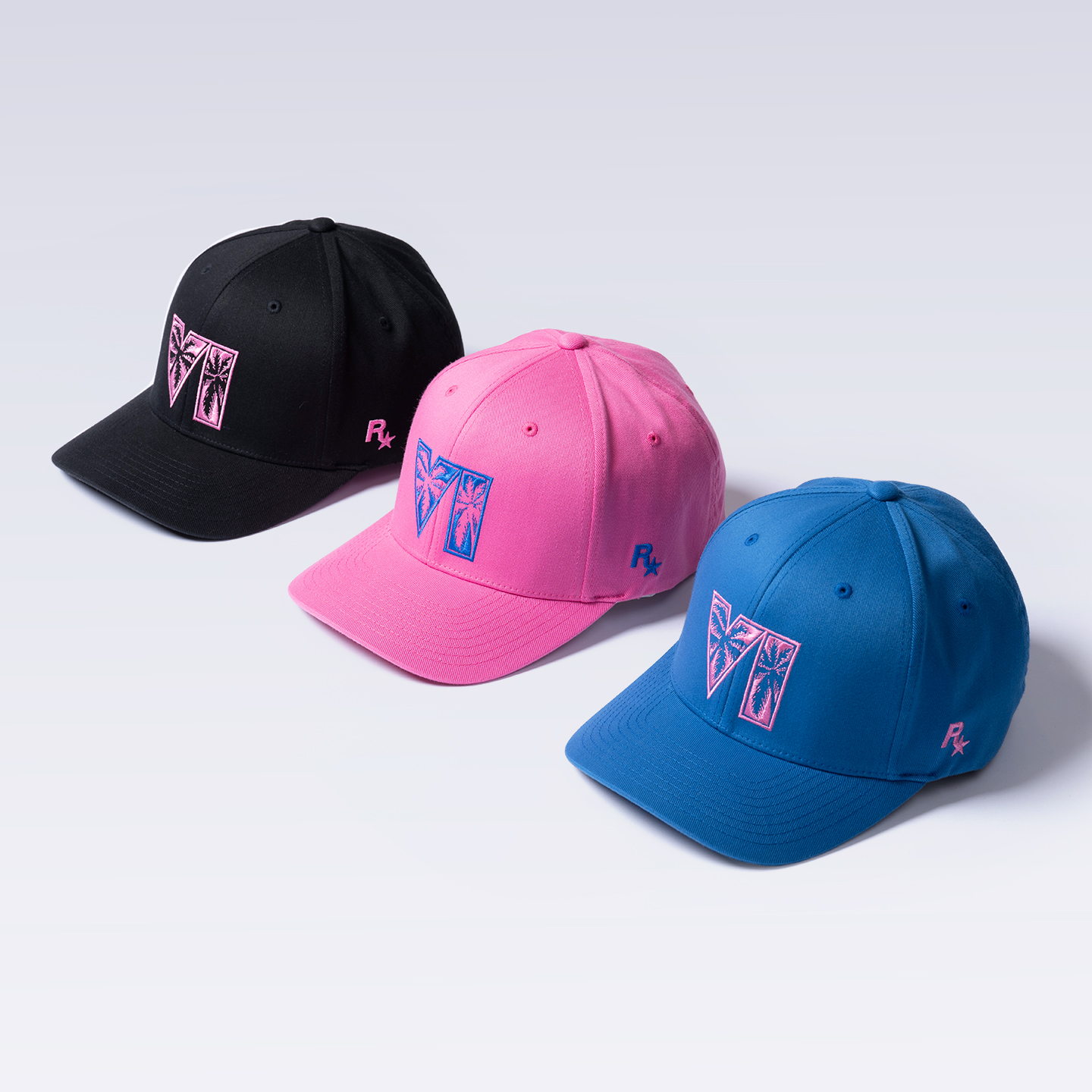 Three GTA 6 baseball caps in black, pink, and blue, all featuring the GTA 6 and Rockstar Games logos.