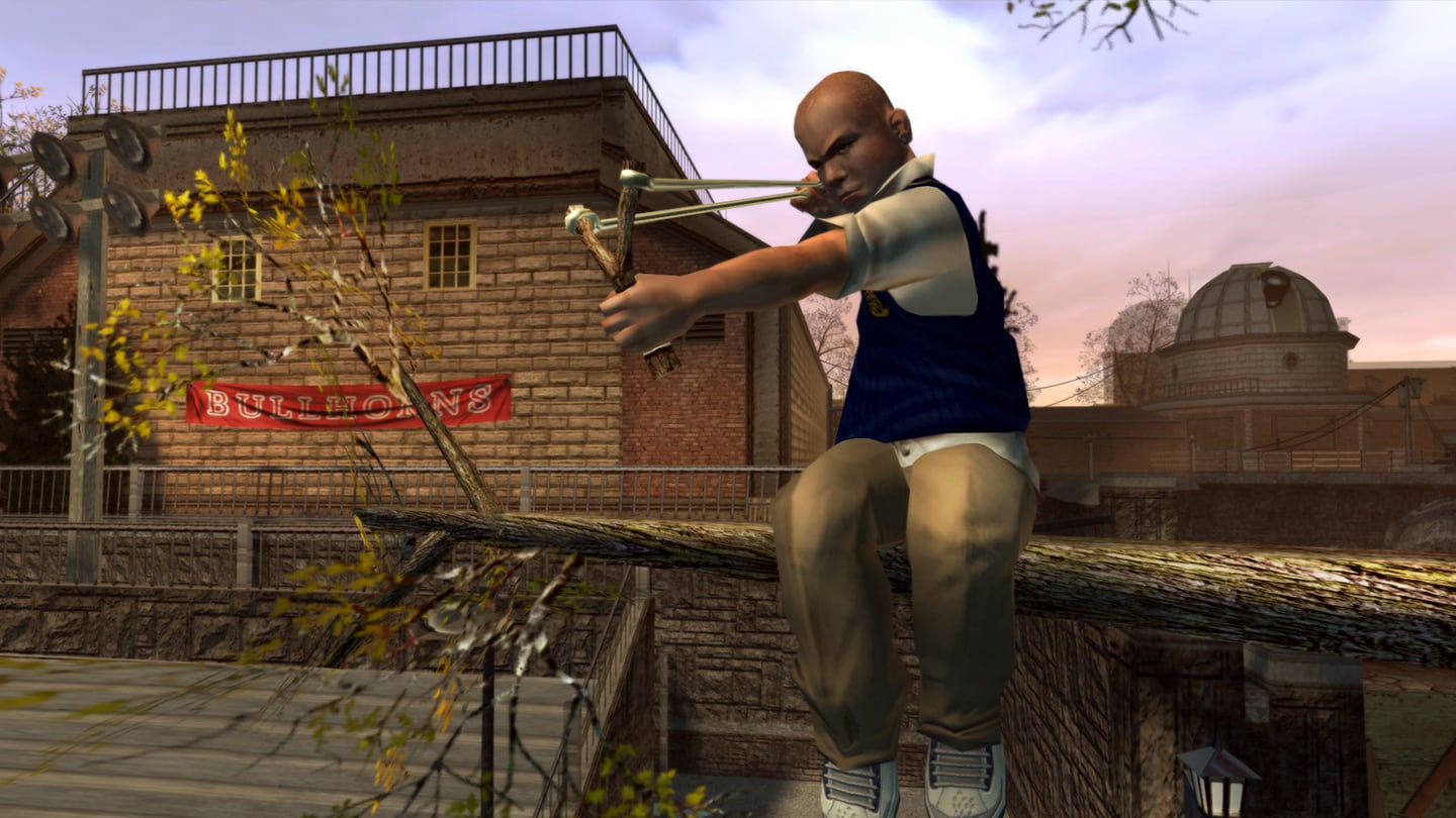 Jimmy sitting in a tree on campus aiming a slingshot ready to fire.